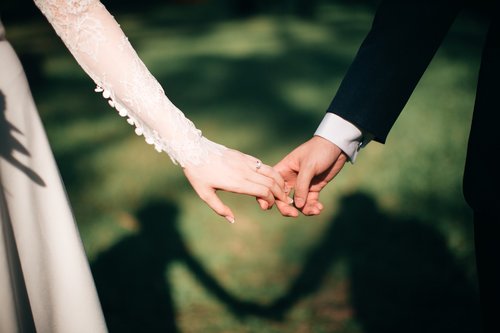 Mies ja nainen käsi kädessä kulkien