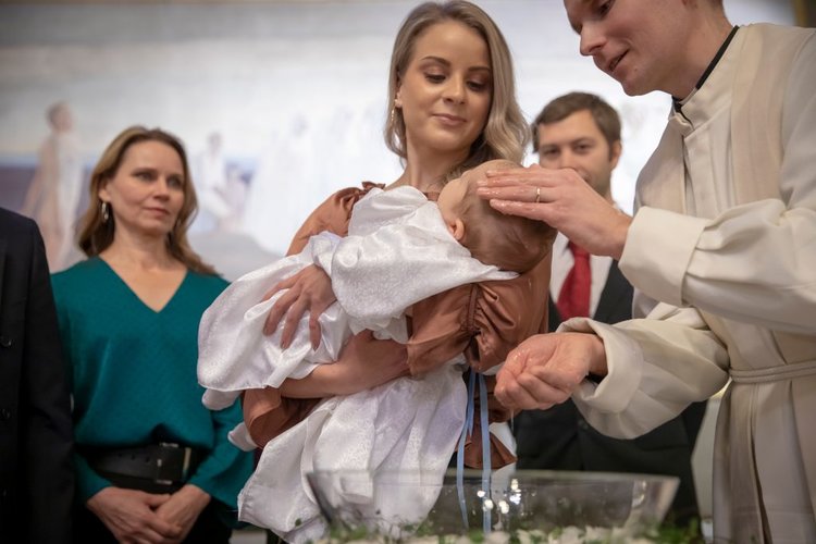 Pappi kastamassa lasta.